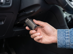 Hand plugging CarVitals into a car's OBD-II port