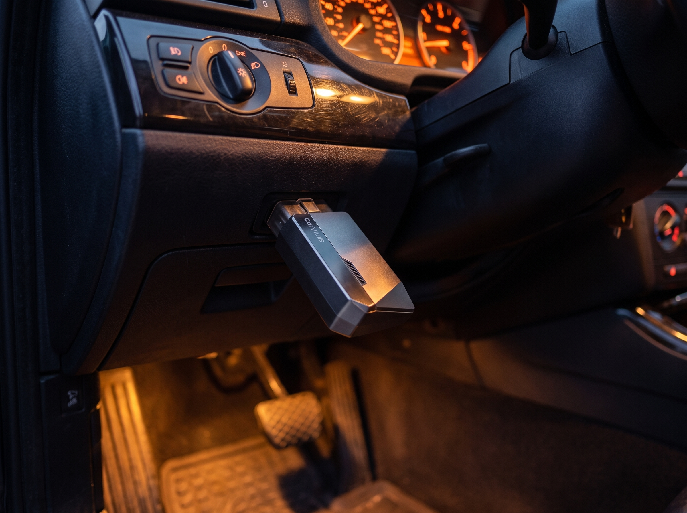 CarVitals plugged in at dusk with warm dashboard lighting